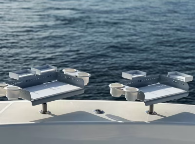 Two gray and white Boat Bait Stations with cupholders and extra tool trays in the fishing rod holders of a boat.